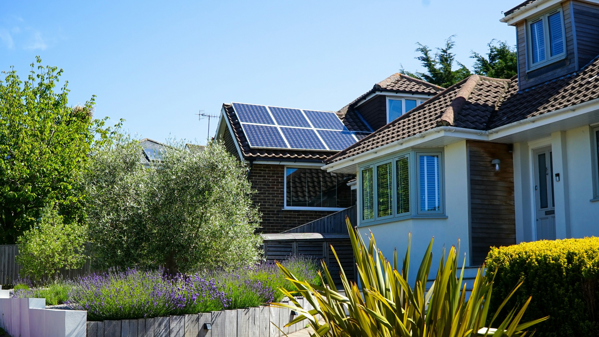 House with solar panels and green garden